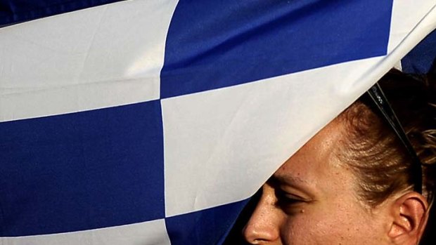 Ready to say no ... a demonstrator holds a Greek flag outside Parliament during protests against austerity measures.