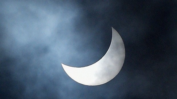 Clouds pass across the sun which is pictured during a partial solar eclipse over the Madeira Islands.
