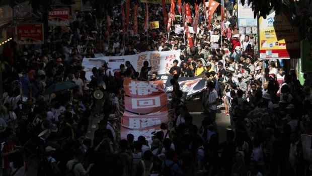 Protesters carrying banners take part in a demonstration march against a Chinese patriotic education course in Hong Kong.