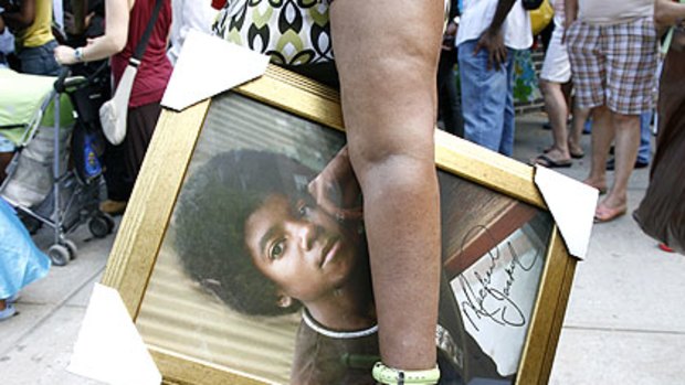 A Jackson fan holds a signed picture of the star outside New York's Apollo Theatre.