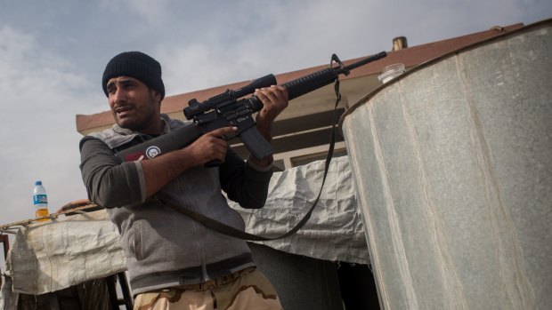 A sniper from the Iraqi Army Armoured Ninth Division takes a break after firing at IS snipers across the Mosul frontline from a rooftop in the Entisar neighbourhood.