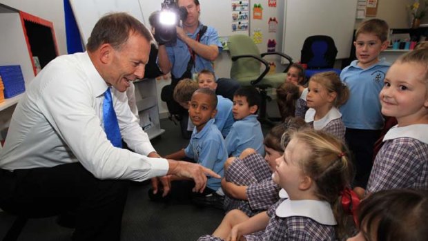 Story time everyone ... Tony Abbott with students at Rosary Primary School in Canberra, where the Leader of the Opposition talked about the wonders of books.