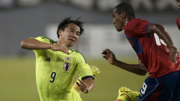 Shinji Okazaki (L) of Japan's national soccer team, the Samurai Blue, collides with Costa Rica's Roy Miller