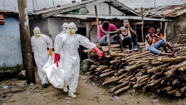 A burial team removes the body an Ebola victim from an isolation ward in West Point, Monrovia.