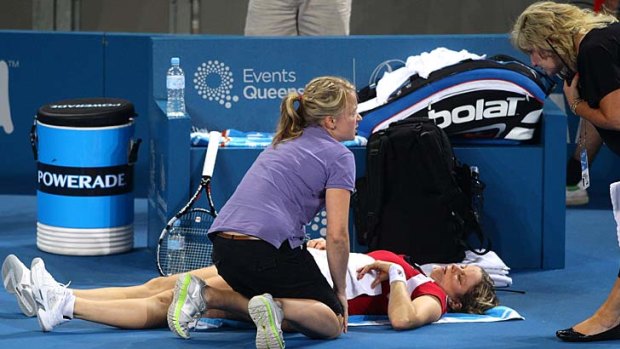 Kim Clijsters lies on the ground after she sustained an injury during her semi-final against Daniela Hantuchova at the Brisbane International.