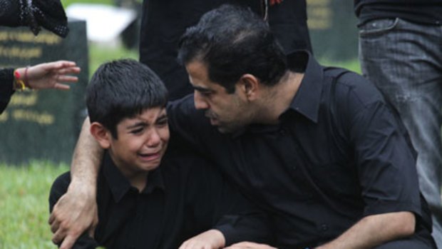 Grief stricken ... Seena, 9, from Iran, at the funeral of his father and two other victims of the Christmas Island tragedy.