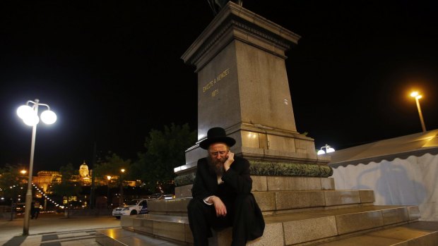 An Orthodox Jewish man sits outside in Budapest, Hungary. 