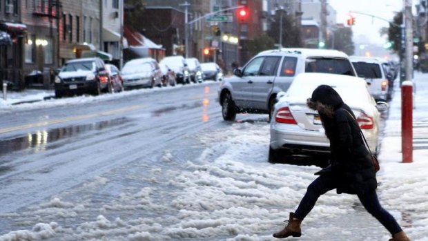 Chilling out:  A woman tries to jump an icy puddle during a snowstorm that hit  New York.