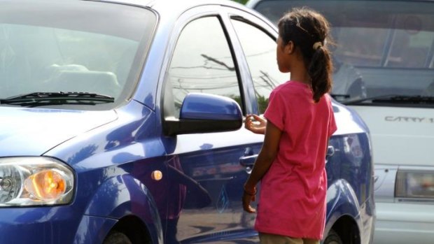 A young girl begs in Benoa square