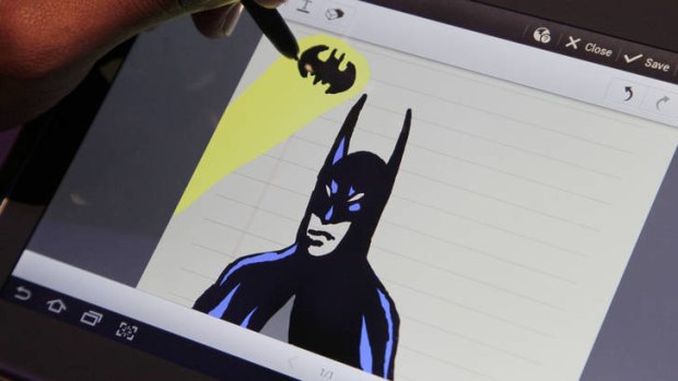An artist uses the Samsung Galaxy Note to draw a Batman figure at the news conference.