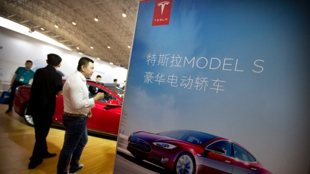 Visitors look at a Tesla Model S electric car on display at the Beijing International Automotive Exhibition in Beijing last year: The electric car marker is yet to crack the Chinese market.