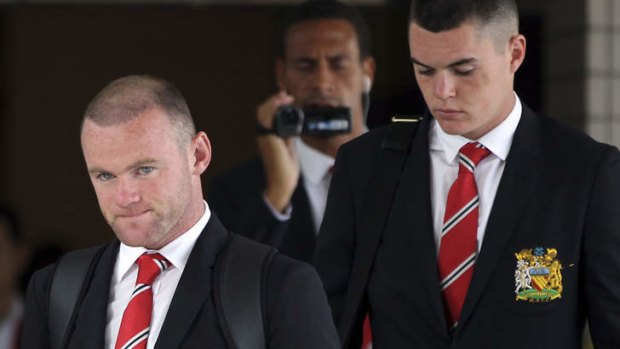 Wayne Rooney, left, arrives in Bangkok on Thursday.