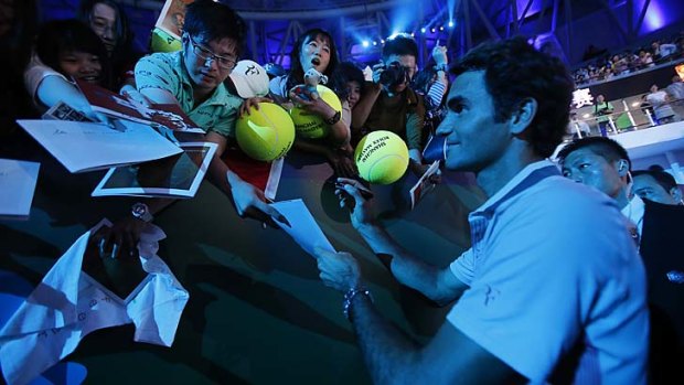 Always charming: Roger Federer signs autographs during a meet-the-fans event before the Shanghai Masters.