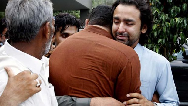 Signs of support: Musa Gilani, right, the brother of Ali Haider Gilani is comforted.