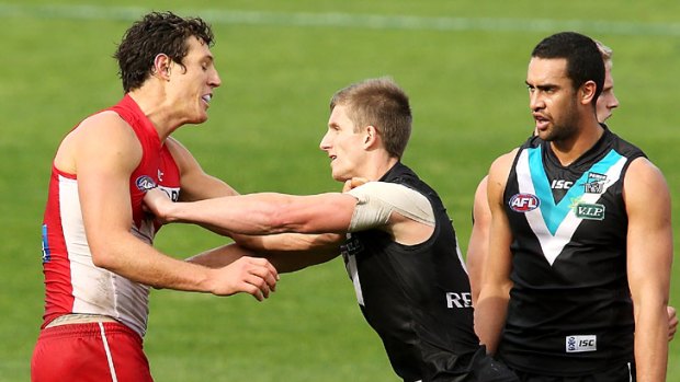Above their weight division: Hamish Hartlett gives new Swan Kurt Tippett a shove during Port's upset victory.