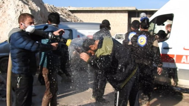 Civil defence workers spray water on victims after the attack. 