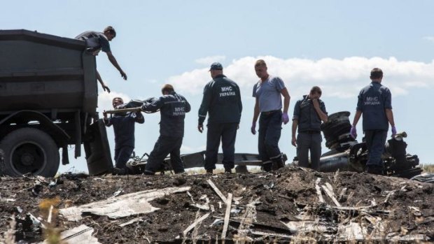 Workers from the Ukranian Emergencies Ministry transfer the bodies of MH17 victims on to a truck on Monday.