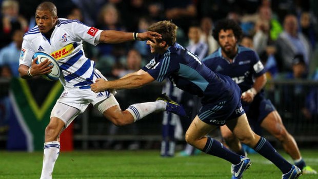 Juan de Jongh of the Stormers beats the tackle from Chris Noakes of the Blues.