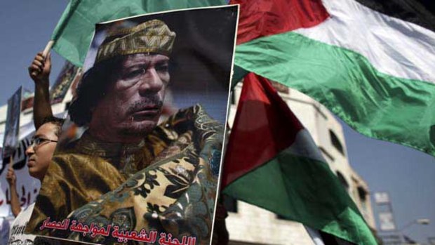 A Palestinian boy holds a poster of Libyan leader Muammar Gaddafi in Gaza City.