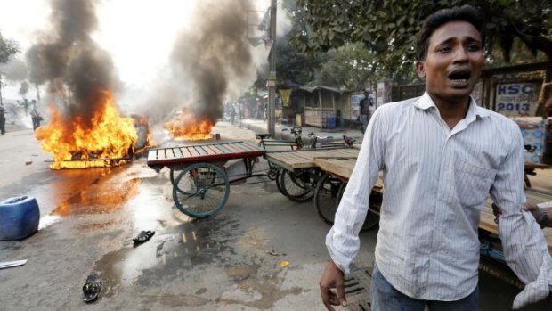 Devastated: A man cries after Jamaat-e-Islami party activists torched his vehicle.
