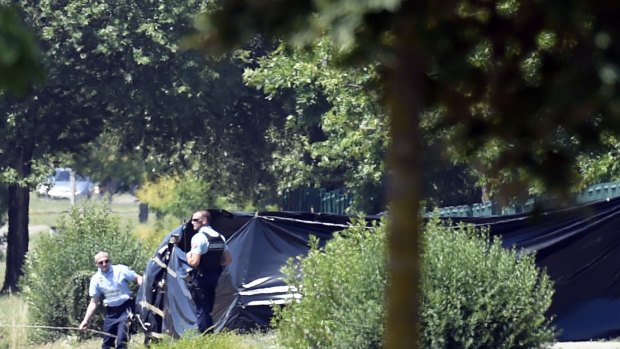 French police erect tents to enclose the area where a decapitated body was found.