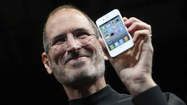 Apple CEO Steve Jobs poses with a white iPhone 4.