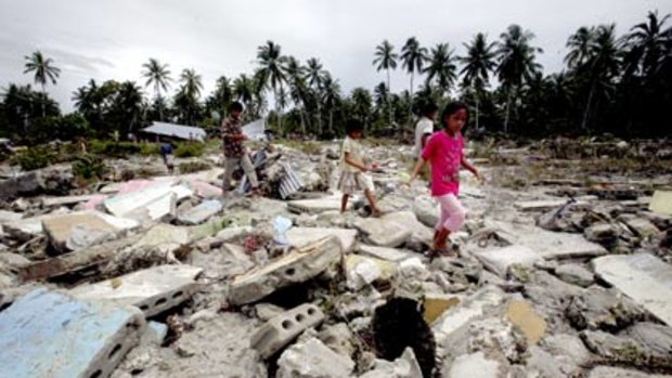 Villagers stumble through the remains of their razed village on Pagai island, west Sumatra.