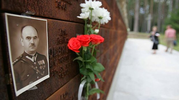 Flowers laid near the portrait of a Polish officer at the memorial wall near the mass graves in Katyn.