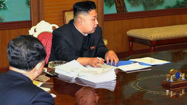 North Korean leader Kim Jong-Un is pictured with a smartphone on his right.