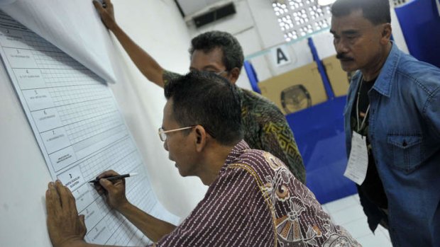 Election officials tally the vote count at a polling station in Jakarta on Wednesday. The result is likely to bring presidential candidate, Jakarta governor Joko Widodo, a step closer to becoming the country's next leader.