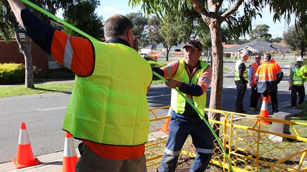 NBN Co workers haul fibre cables in South Morang, where foresight by council meant conduits were installed ahead of demand.