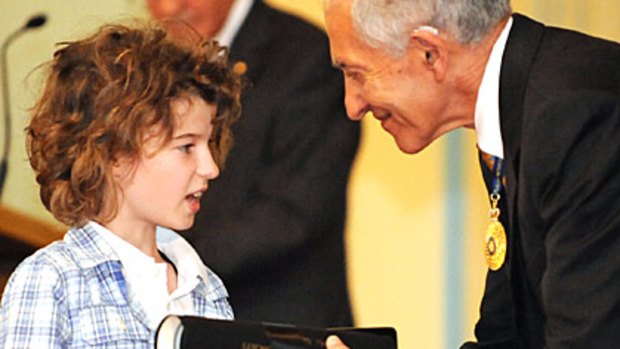 Charlie Keilar, the son of slain solicitor Brendan Keilar, accepts a bravery award for his father's heroic actions from Victoria Governor David de Kretser.