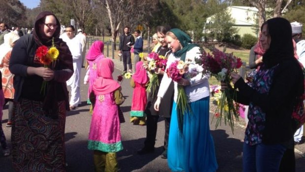 Floral gesture: Ten Canberran women hand out flowers to the ACT Islamic community in Bruce on Saturday