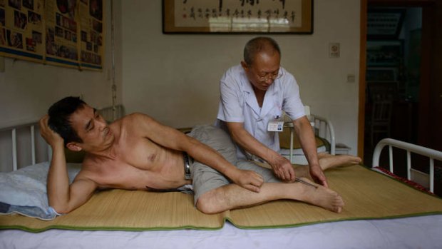 A patient receives a bee sting administered by a doctor of traditional Chinese medicine at a clinic on the outskirts of Beijing.
