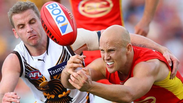 Quick hands: Gold Coast skipper Gary Ablett has eyes only for the ball while under pressure from Hawk Rick Ladson.