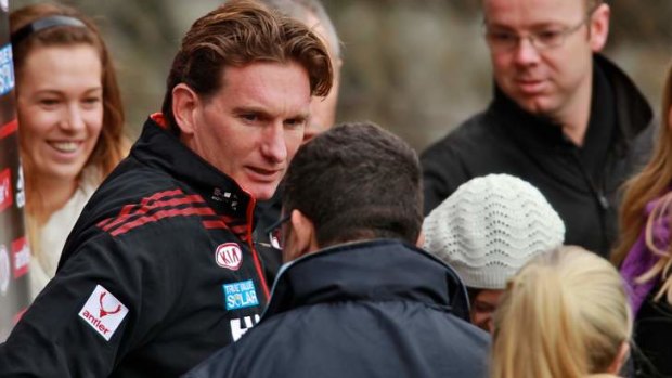 Under fire: Essendon coach James Hird is surrounded by media and fans at Windy Hill on Friday.