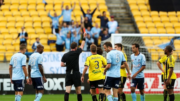 Referee Peter Green shows a red card to Wellington's Albert Riera.