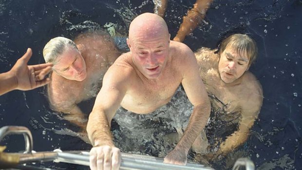 Saved: Brett Archibald climbs aboard the rescue yacht.