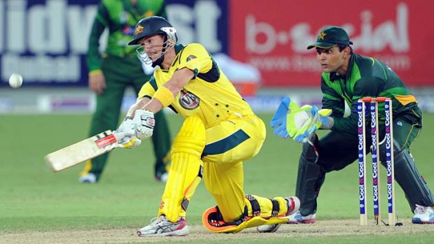 Australia captain George Bailey hoicks a ball over mid-wicket as Pakistan wicketkeeper Kamran Akmal looks on during the second Twenty20 international match between the teams.