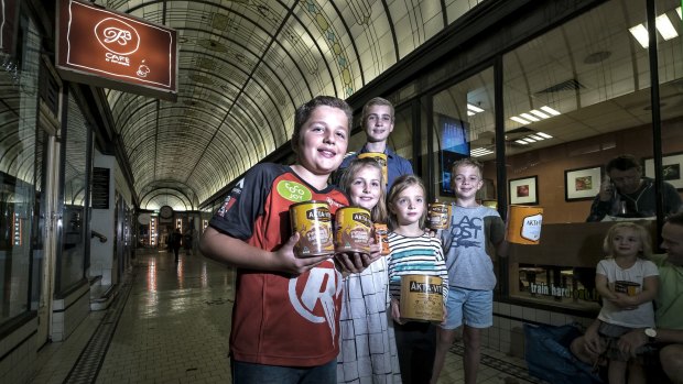 Some of Alfred Nicholas' great-great-grandchildren in the Nicholas building on Swanston Street with tins of Akta-Vite.