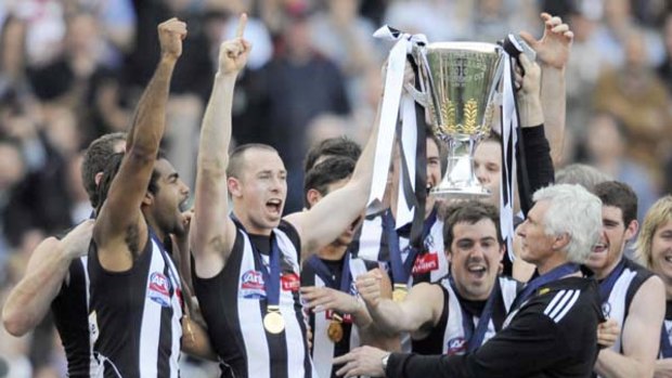 Collingwood coach Mick Malthouse joins his players on the premiership podium to celebrate yesterday's emphatic win over St Kilda.