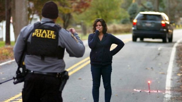 A resident talks with a Pennsylvania State Trooper, as a section of Lower Swiftwater Road was closed during the manhunt for suspected killer Eric Frein in Swiftwater.