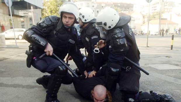 A protester is detained by police during riots in Belgrade.