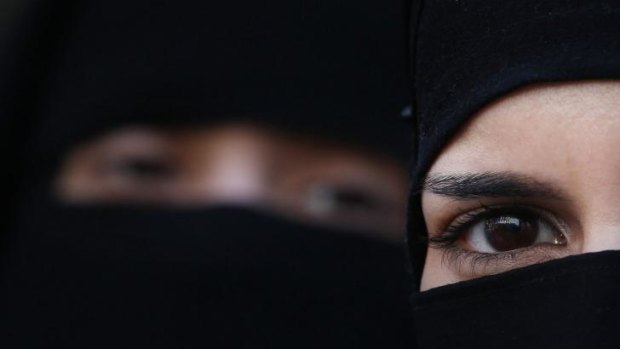 Two women wearing Islamic niqab veils stand outside the French Embassy in London during a demonstration in 2011.