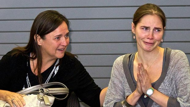 Emotional ... Amanda Knox acknowledges the cheers of supporters while her mother Edda Mellas comforts her after touching down in Seattle.