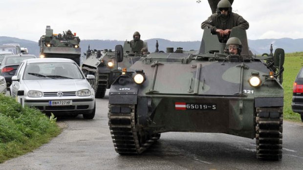 Austrian  soldiers in armored vehicles arrive near the villages of Grosspriel and Kollapriel   where a man had barricaded himself inside a farm building after he allegedly  killed three police officers and a paramedic.