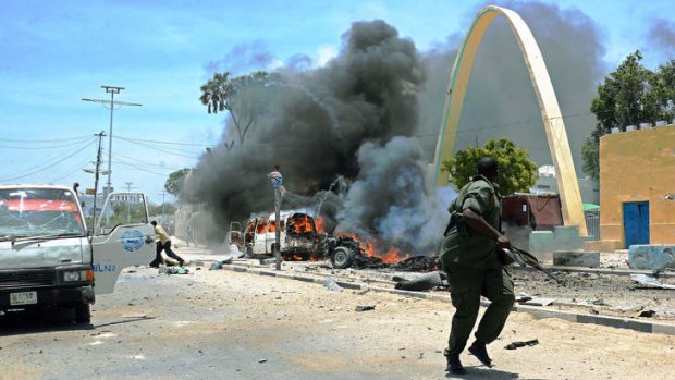 Islamist resurgence ... a member of the Somali security forces flees the site of the car bomb.