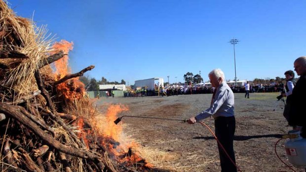 Mayor Cr Geoff Dobson lights a bonfire at the rally.