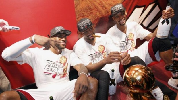 Miami Heat's LeBron James, Dwyane Wade and Chris Bosh sit with the Larry O'Brien Trophy after their team defeated the San Antonio Spurs in Game 7 to clinch the NBA Finals in Miami last June.