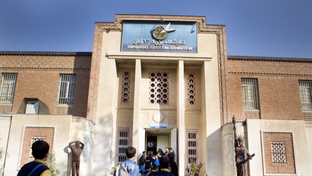 Iranian students walk inside of one of the buildings of the former US embassy. 